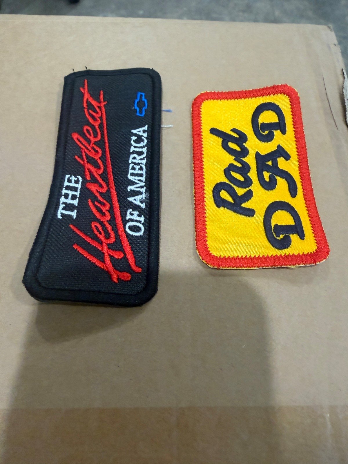 Two custom embroidered patches on a work table